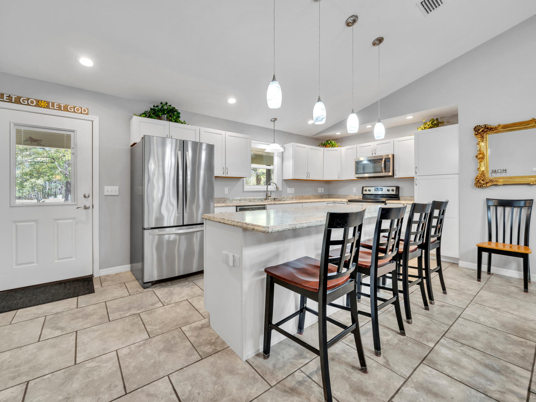 5346 Fox Hound Lane Baker, FL 32531 - Photo 14 of 46 a kitchen with stainless steel appliances a table chairs refrigerator and a sink