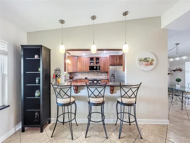 a kitchen with stainless steel appliances a table and chairs in it
