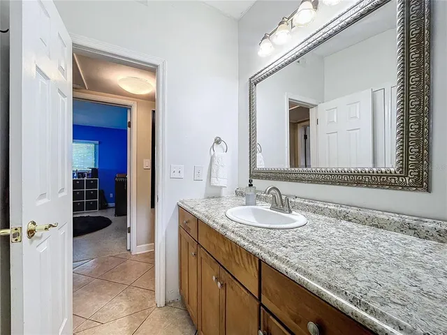 a bathroom with a granite countertop double vanity sink and a mirror