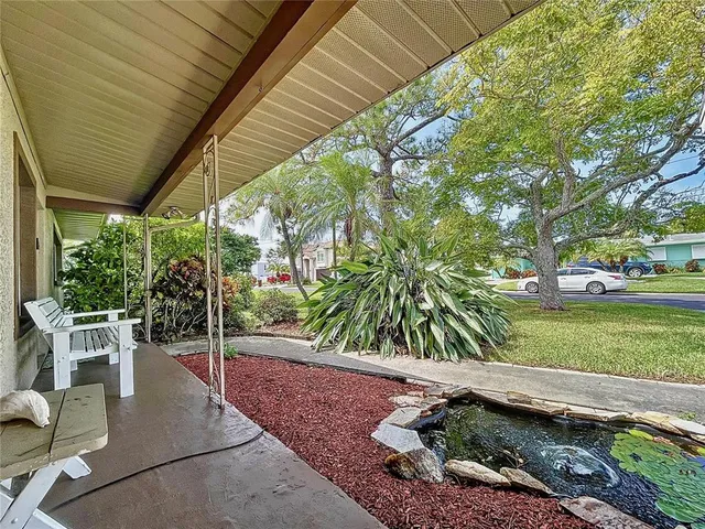 a view of a patio with table and chairs potted plants and palm trees