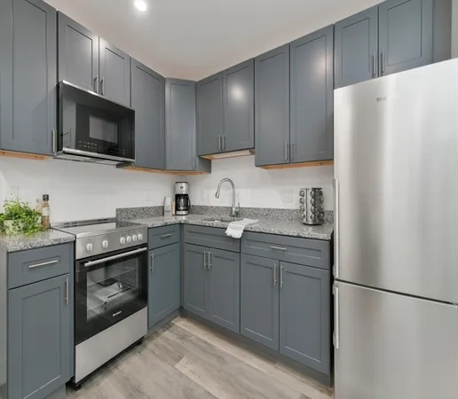 a kitchen with stainless steel appliances granite countertop a refrigerator stove a sink and dishwasher with wooden cabinet