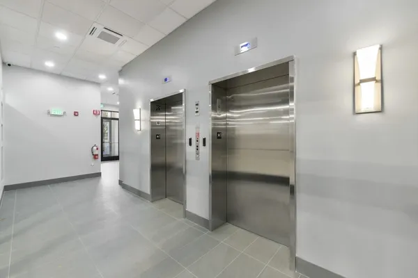 a view of a refrigerator in kitchen and an empty room