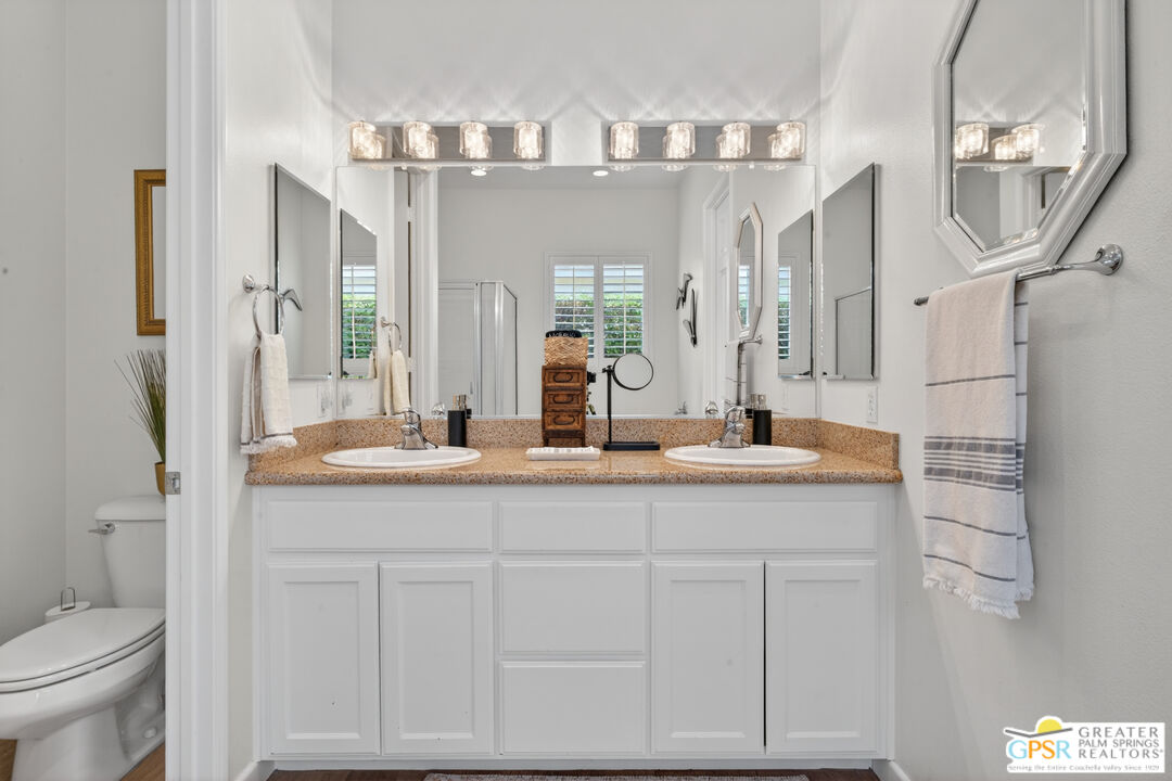 82717 Barrymore Street Indio, CA 92201 - Photo 14 of 26 a bathroom with a granite countertop sink a toilet and a mirror