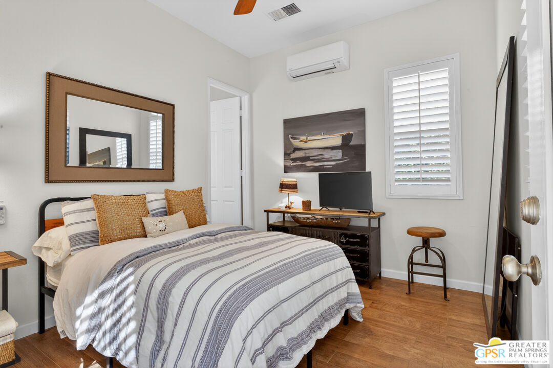 82717 Barrymore Street Indio, CA 92201 - Photo 23 of 26 a bedroom with a bed and wooden floor