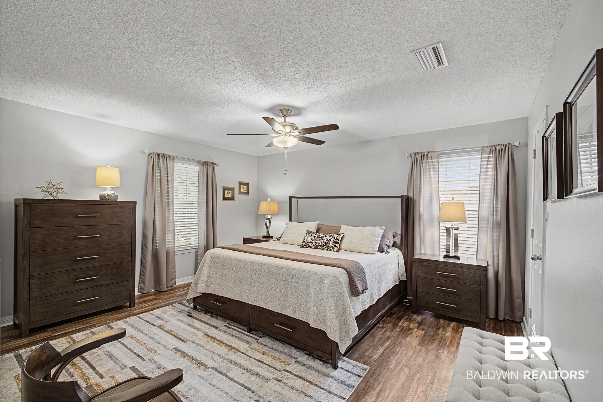 2808 Pine Ridge Drive Lillian, AL 36549 - Photo 17 of 47 Spacious room featuring wood-finish flooring, light grey walls, a ceiling fan, and two windows with blinds