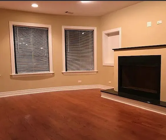 a view of an empty room with a fireplace and a window