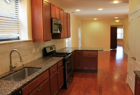 a kitchen with granite countertop a sink and a stove top oven