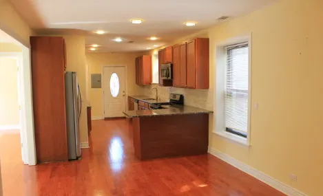 a view of kitchen with granite countertop cabinets and refrigerator