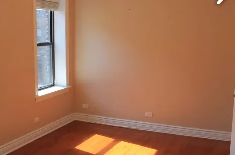a view of a small space with wooden floor and a window