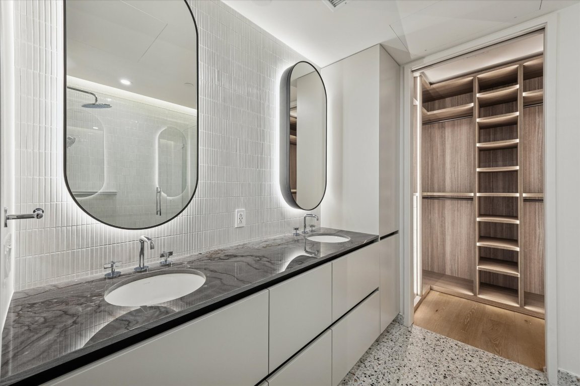 610 Davis Street, Unit 3005 Austin, TX 78701 - Photo 11 of 24 a bathroom with a granite countertop double vanity sinks and a mirror