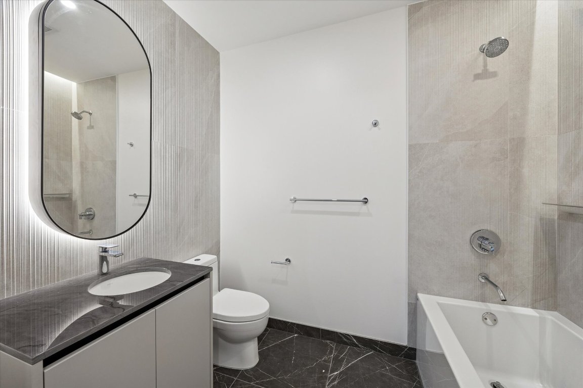 610 Davis Street, Unit 3005 Austin, TX 78701 - Photo 13 of 24 a bathroom with a granite countertop sink a toilet and shower