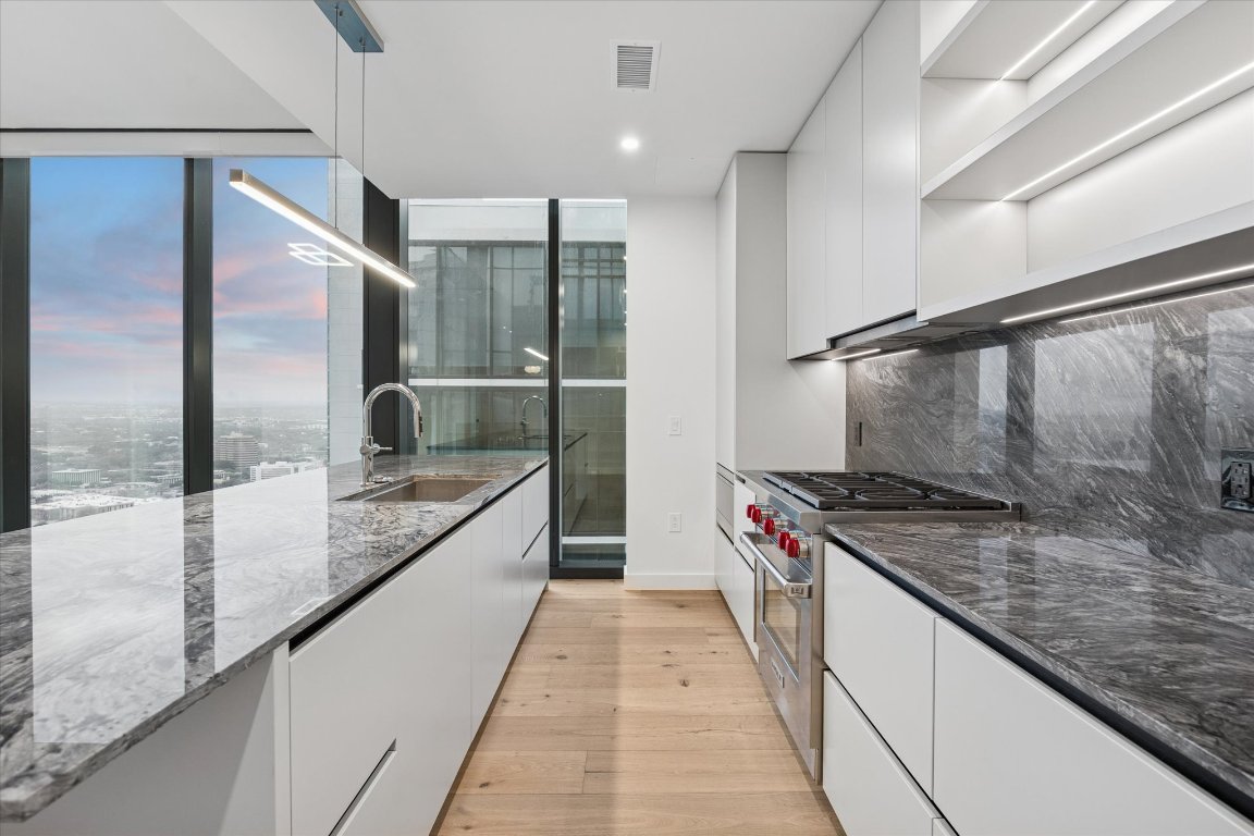 610 Davis Street, Unit 3005 Austin, TX 78701 - Photo 6 of 24 a kitchen with stainless steel appliances granite countertop a sink and a refrigerator