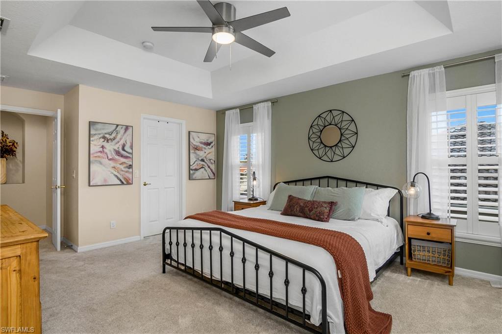 12454 Rock Ridge Lane Fort Myers, FL 33913 - Photo 14 of 37 a bedroom with a large bed and a chandelier