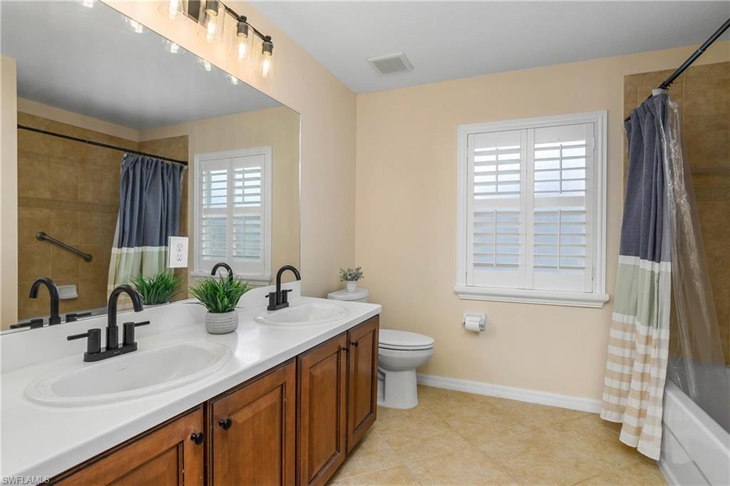 12454 Rock Ridge Lane Fort Myers, FL 33913 - Photo 22 of 37 a bathroom with a double vanity sink a toilet and a mirror