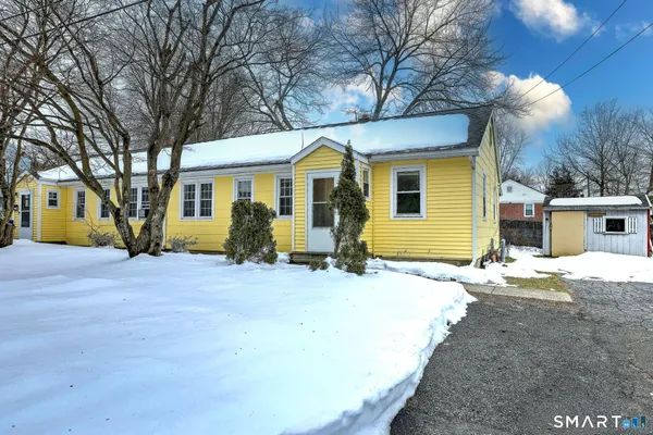 a front view of a house with a yard garage and chair
