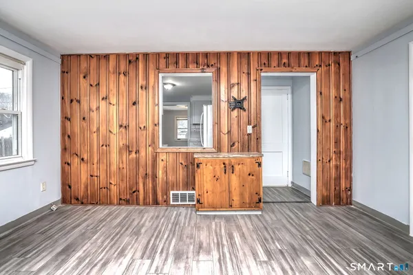 an empty room with wooden floor and a window