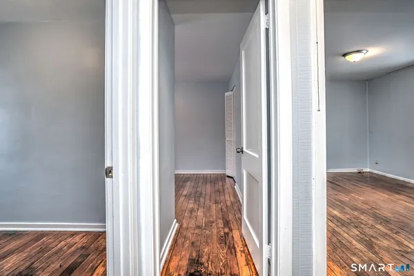 a view of a hallway with wooden floor and staircase