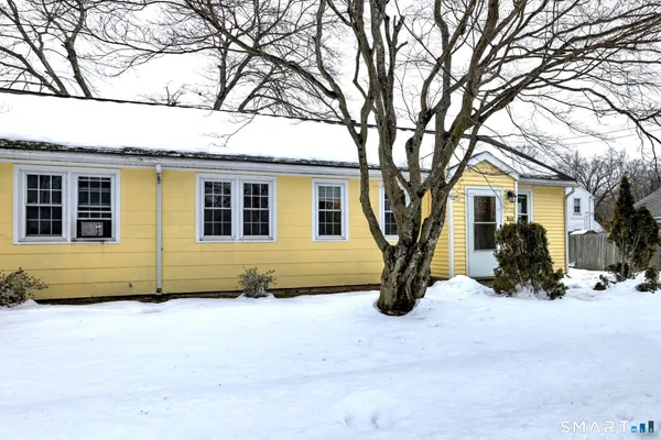 a view of house with a yard covered in snow