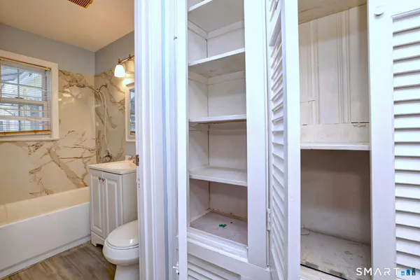 a bathroom with a granite countertop toilet a sink and bathtub