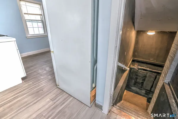 a view of a hallway with wooden floor and staircase