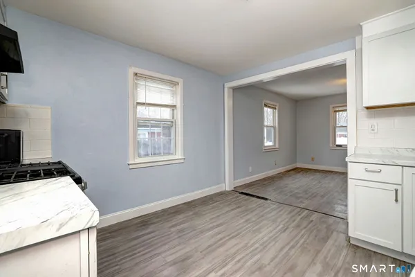a view of a kitchen with wooden floor and electronic appliances