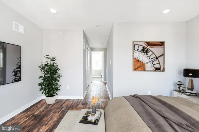 a bedroom with a bed and a wooden floor