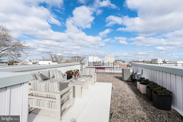 a view of a terrace with lawn chairs and iron fence
