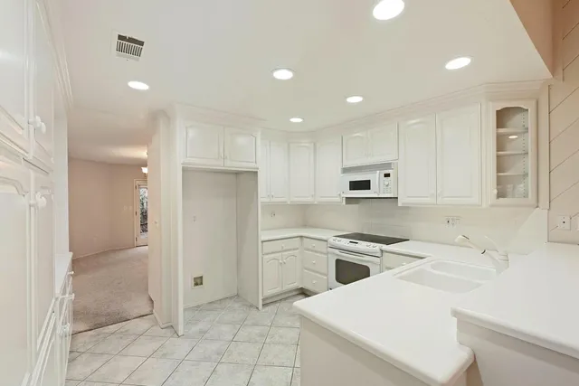 a kitchen that has a sink a refrigerator and a stove top oven