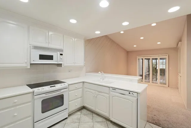 a kitchen with white cabinets and sink