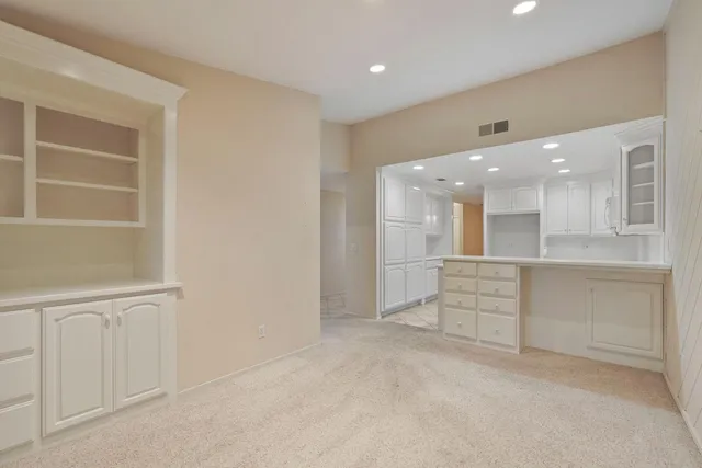 a kitchen with kitchen island white cabinets and refrigerator