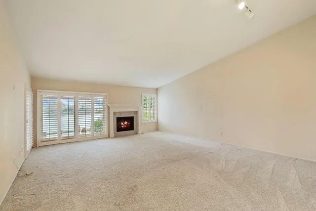 an empty room with a fireplace and window