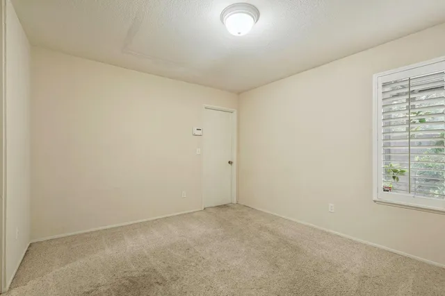 an empty room with windows and closet
