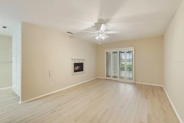 an empty room with a fan and a ceiling fan