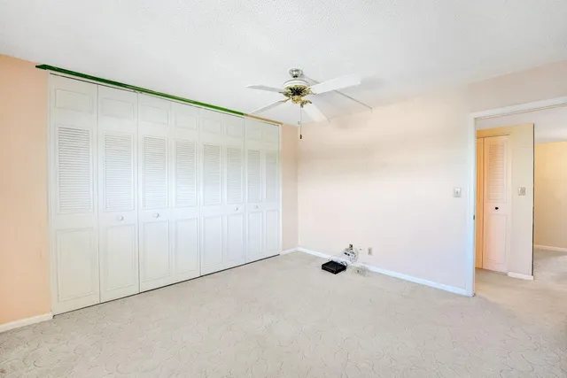 an empty room with a ceiling fan and a window