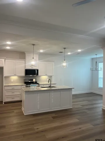 a kitchen with stainless steel appliances a sink a stove a refrigerator and cabinets