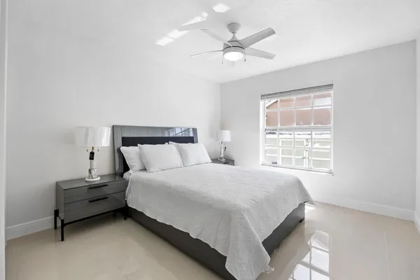 a bedroom with a bed lamp and a window