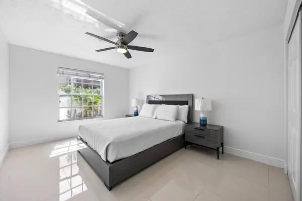 a bedroom with a large bed and a ceiling fan