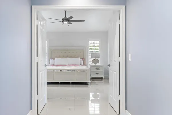 a spacious bedroom with a bed and a ceiling fan