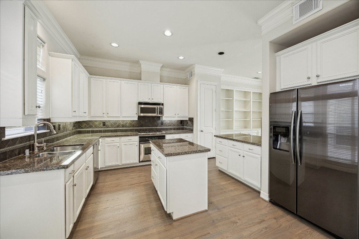 633 Hartman Street Houston, TX 77007 - Photo 6 of 23 a kitchen with white cabinets and stainless steel appliances
