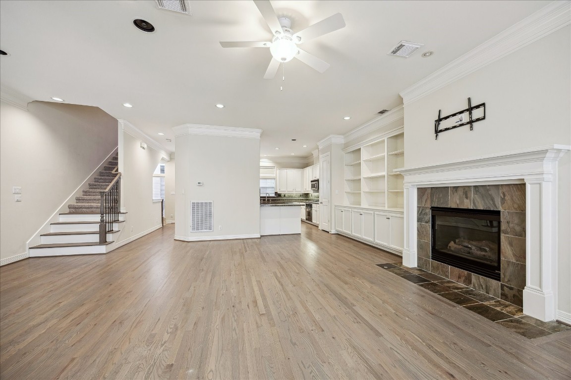 633 Hartman Street Houston, TX 77007 - Photo 10 of 23 a view of an empty room with wooden floor fire place and a kitchen