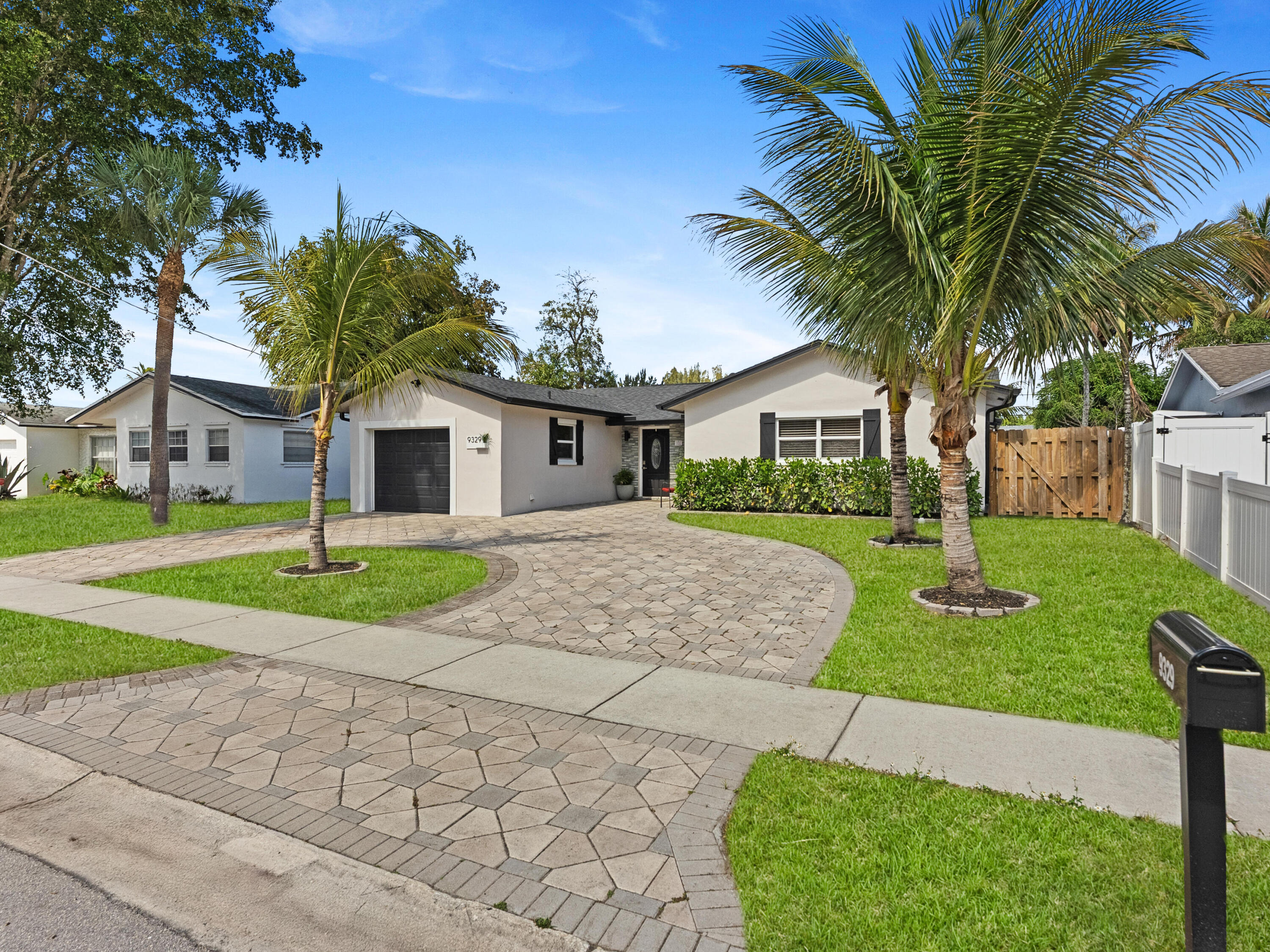 9329 Southwest 2nd Street Boca Raton, FL 33428 - Photo 1 of 42 a front view of a house with a yard and garage