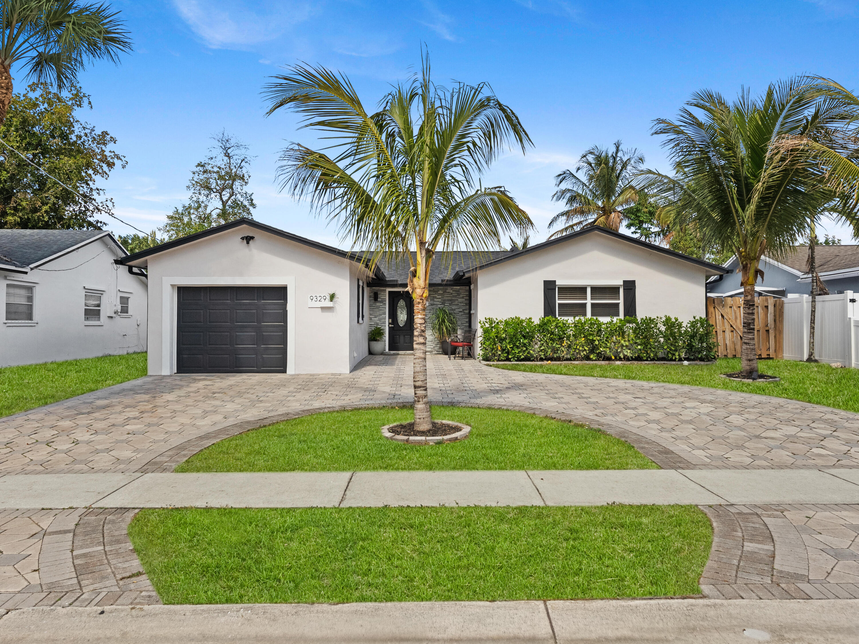 9329 Southwest 2nd Street Boca Raton, FL 33428 - Photo 3 of 42 a house with palm tree in front of it