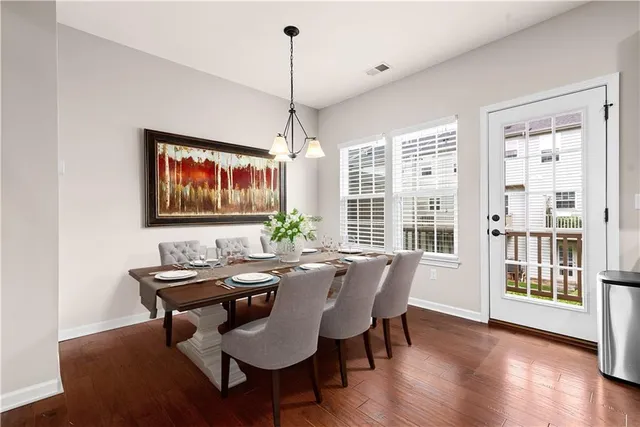 a dining room with furniture a chandelier and wooden floor