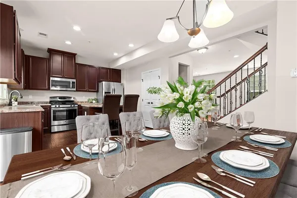 a kitchen with stainless steel appliances kitchen island granite countertop a dining table and chairs