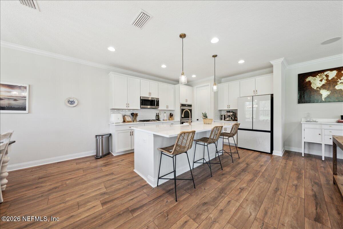 223 Tanner Trail St. Augustine, FL 32092 - Photo 16 of 44 a kitchen with stainless steel appliances a dining table chairs microwave and sink