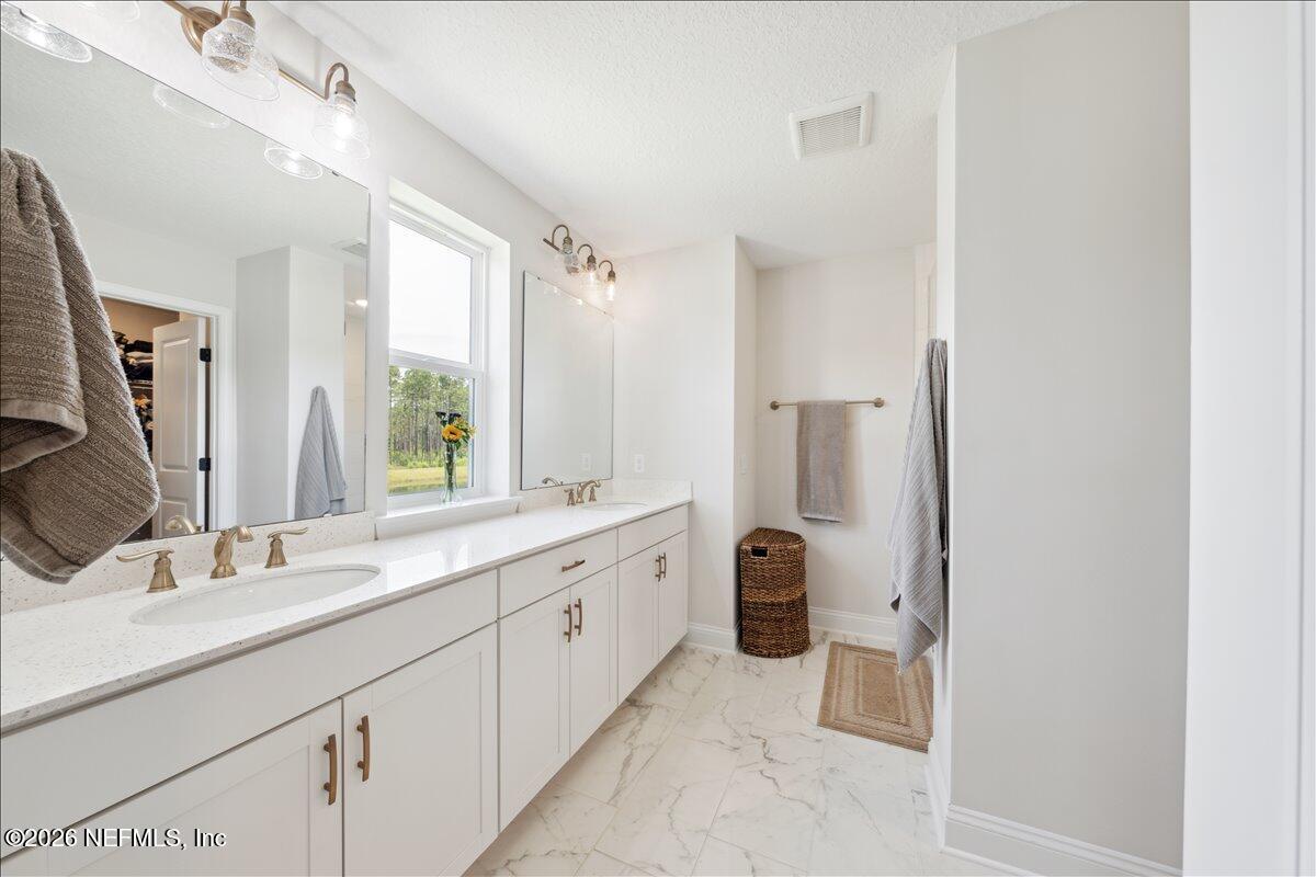 223 Tanner Trail St. Augustine, FL 32092 - Photo 25 of 44 a bathroom with a double vanity sink toilet and shower