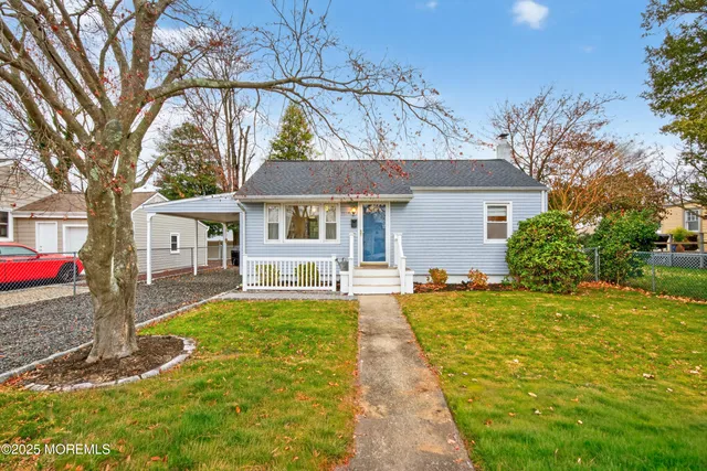 a front view of a house with a yard and trees