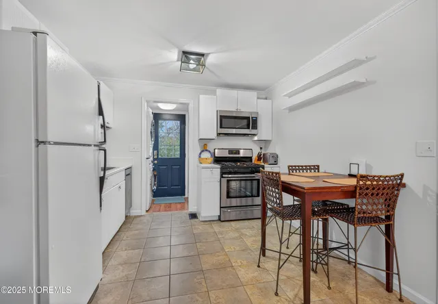 a kitchen with stainless steel appliances a refrigerator and a stove top oven