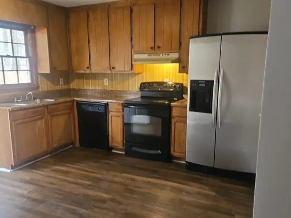 a kitchen with stainless steel appliances granite countertop a refrigerator a stove a sink and a microwave