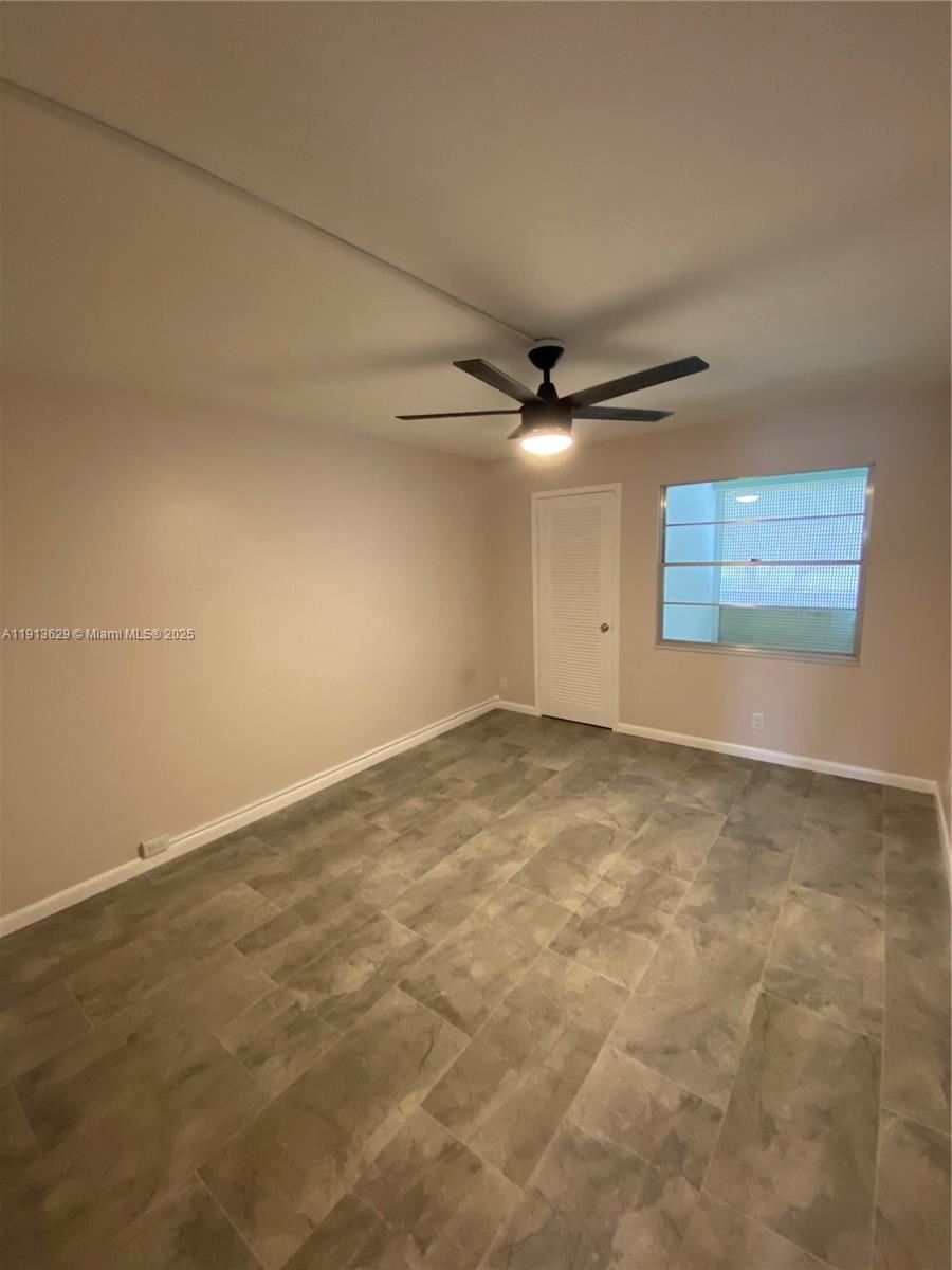 2022 Newcastle B, Unit 2022 Boca Raton, FL 33434 - Photo 12 of 21 en empty room with windows and ceiling fan